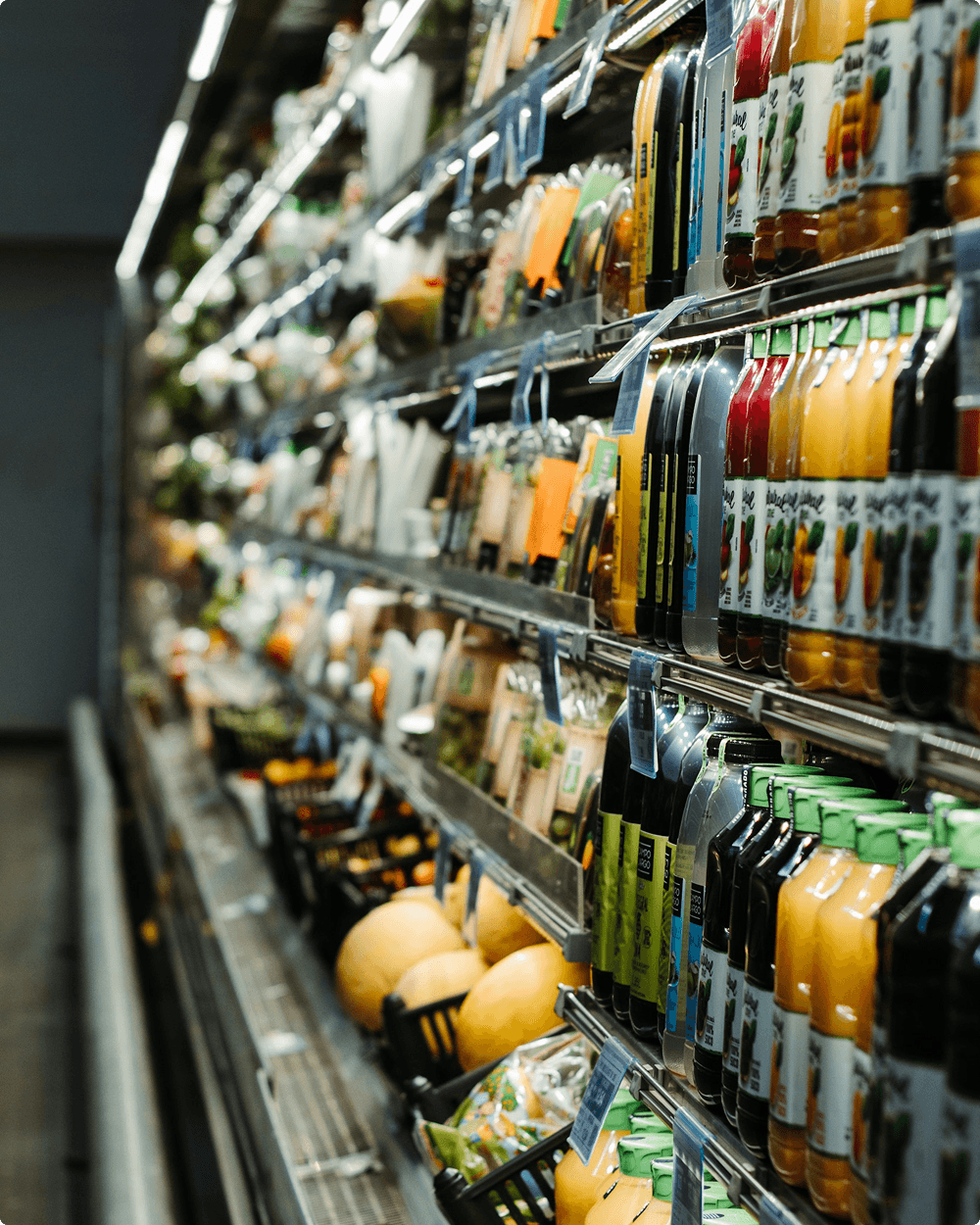 Pasillo de supermercado iluminado con clientes comprando entre estanterías llenas de producto